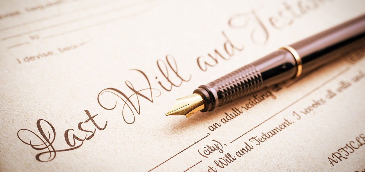 A fountain pen on top of papers titled "Last will and Testament"